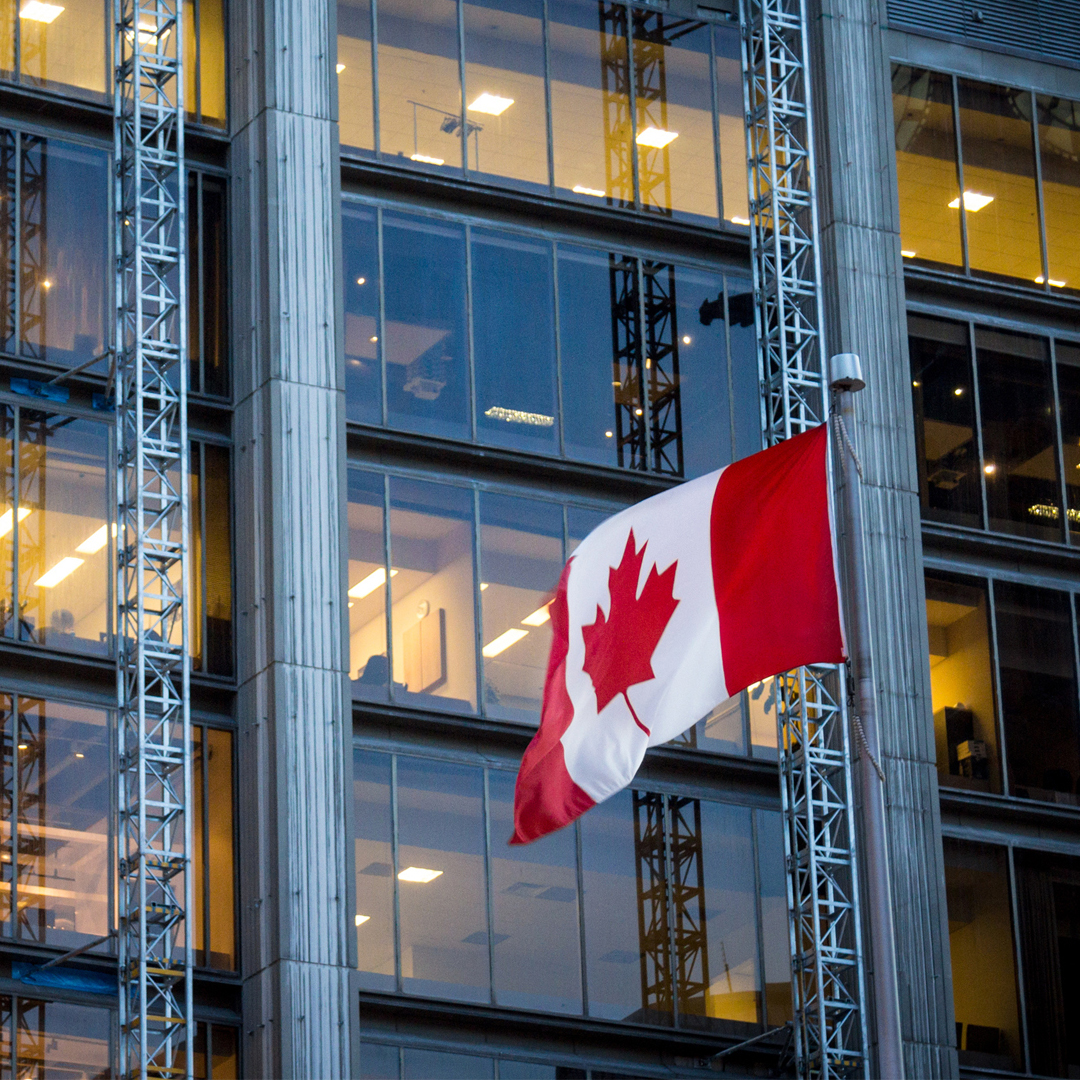Canadian flag in front of business buildings